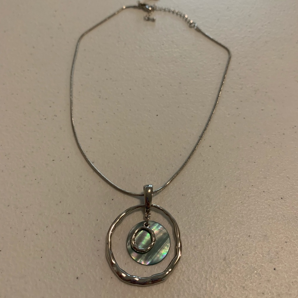 Silver colored necklace with round pendant